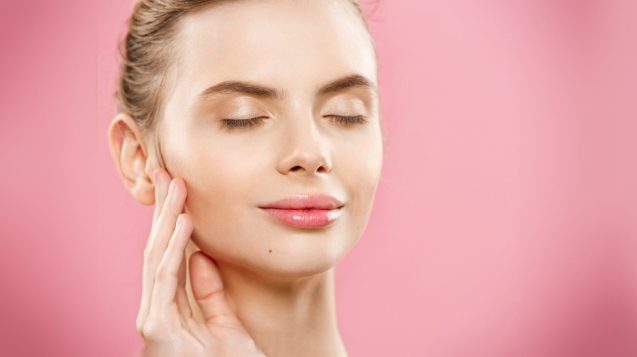 Beauty skin Concept - Beautiful Young Caucasian Woman with Clean Fresh Skin look away with pink studio background. Girl beauty face care. Facial treatment. Cosmetology.