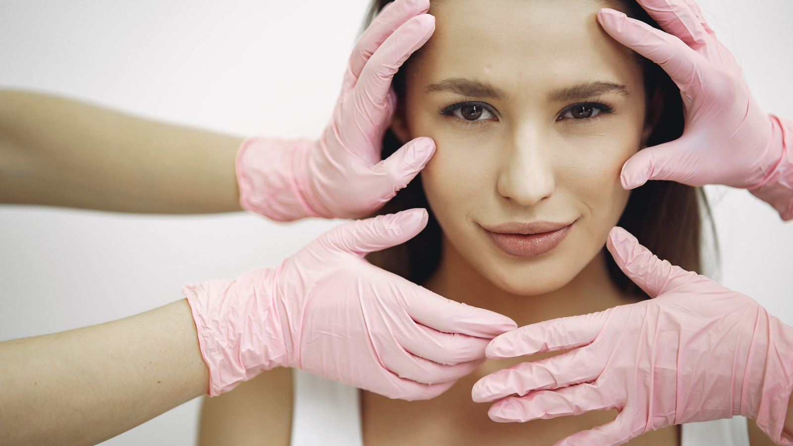 Cosmetology theme. Lady in a beauty studio. Hands in gloves near the girl's face.